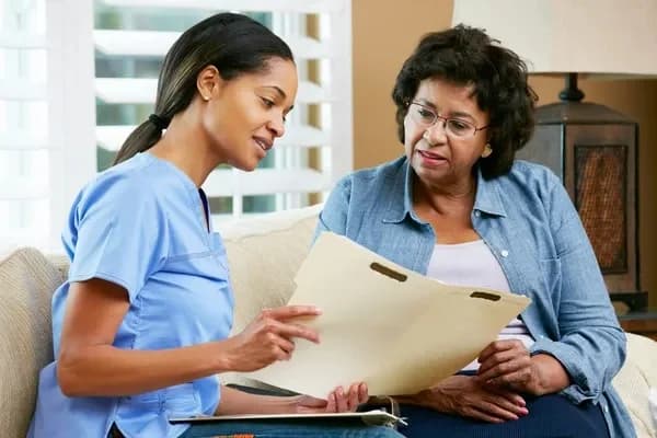 Home care nurse reviewing documents with patient
